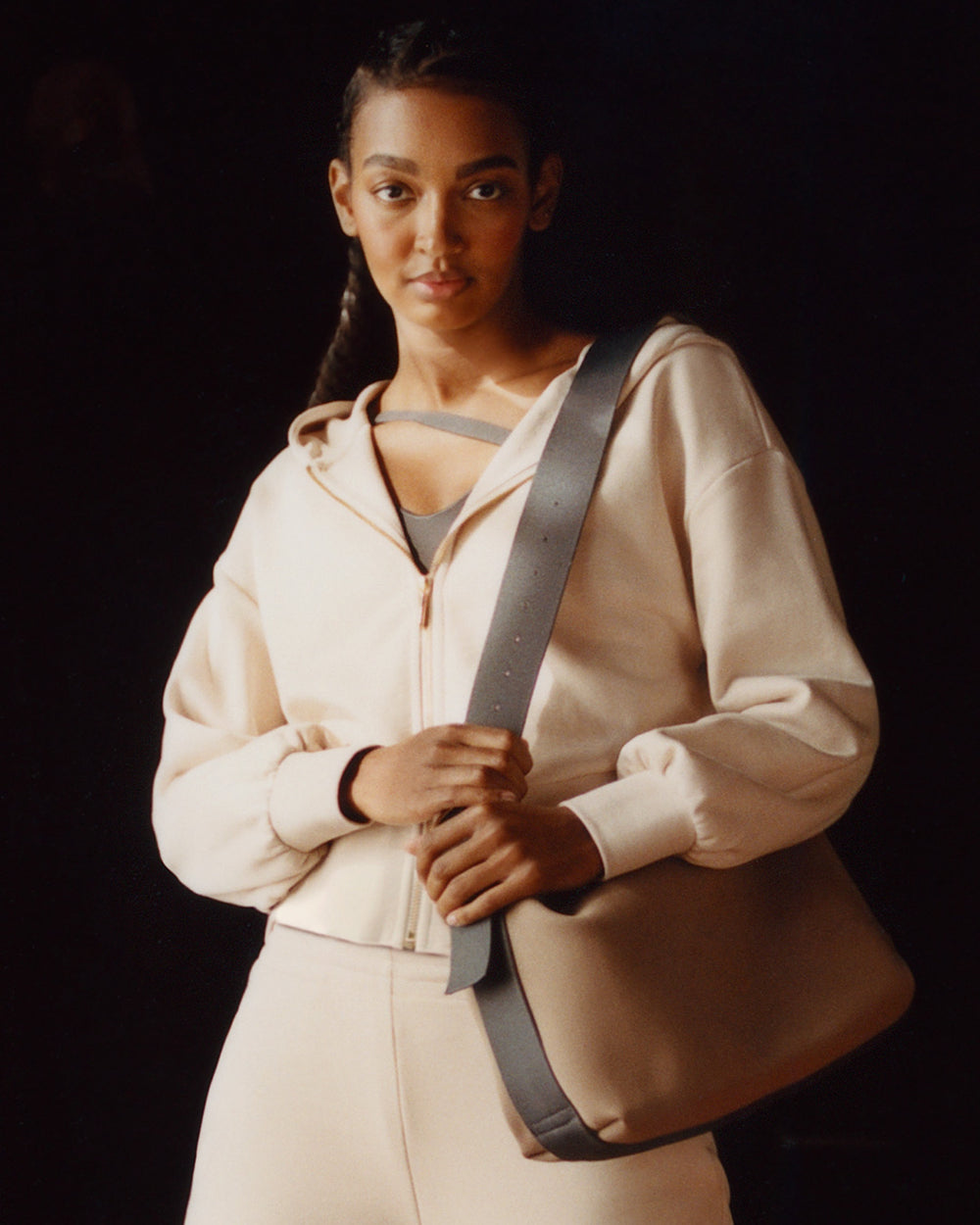 Person wearing a hoodie with a shoulder bag over their left shoulder