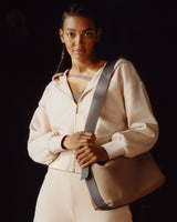 Person wearing a hoodie with a shoulder bag over their left shoulder