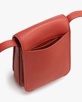 Small shoulder bag with flap closure and adjustable strap.
