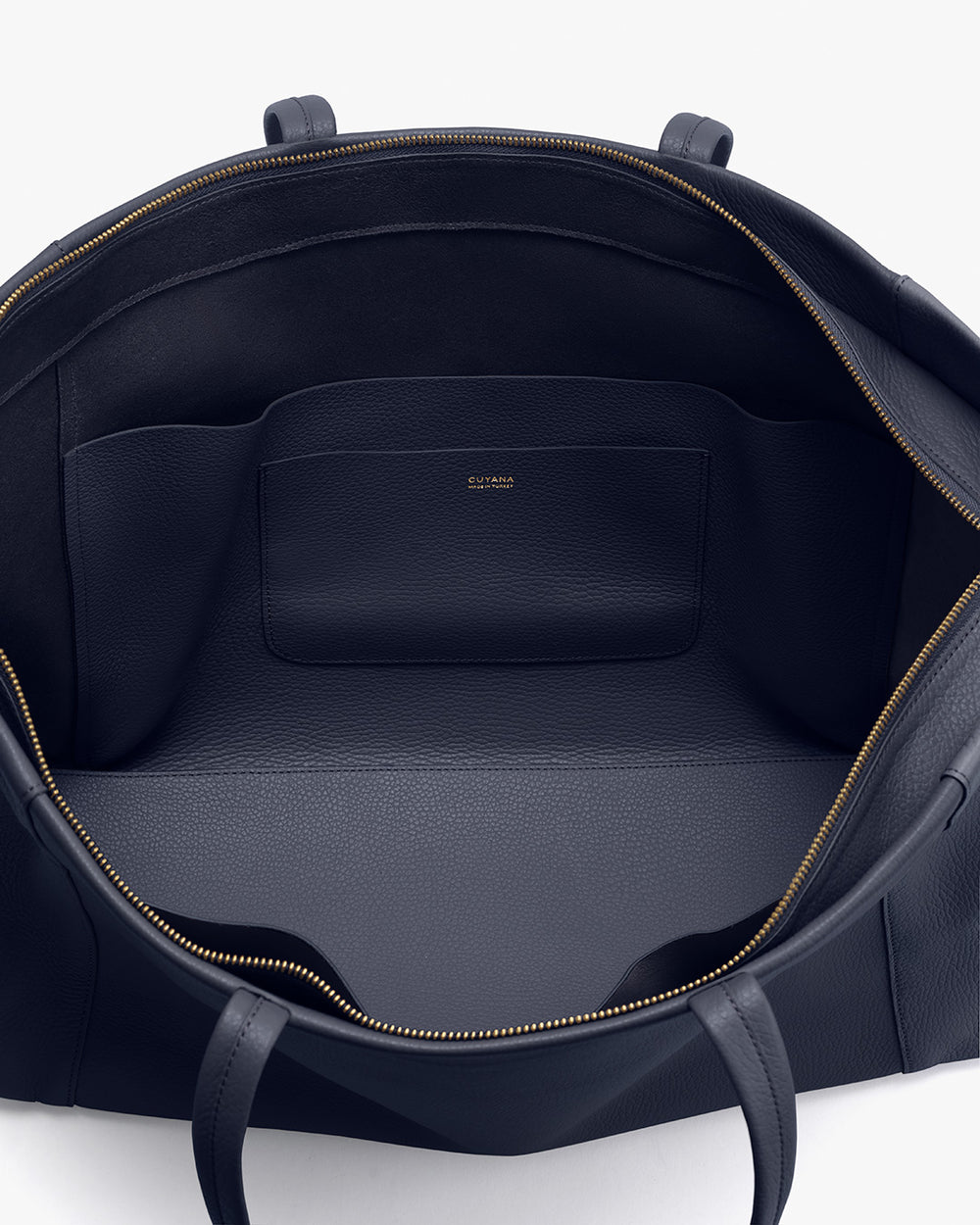 Open handbag interior showing one main compartment and a small pocket.