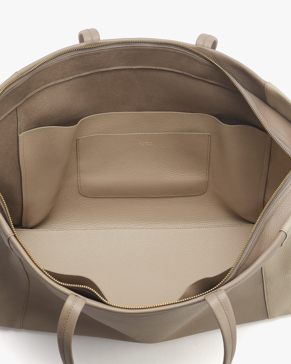 Inside view of an open leather bag showing pockets and zipper.