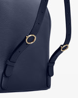 Close-up view of a handbag with adjustable straps and metal rings.