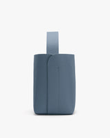 Small vertical purse with a loop handle on top.