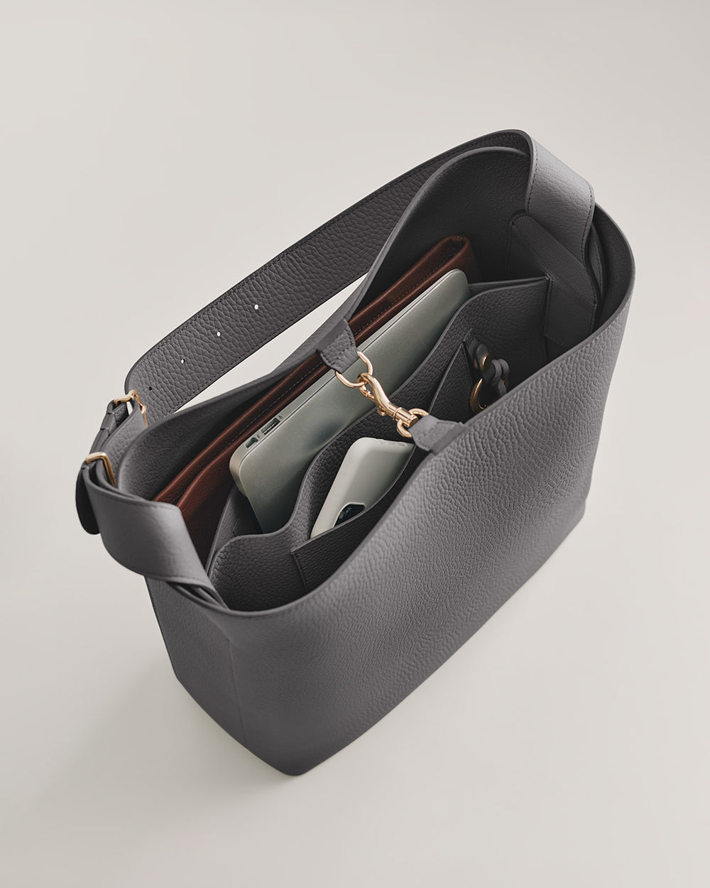 Oversized Linea Bag Handbag with contents visible, including a notebook and a smartphone.