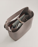 Open handbag with a phone and eyeglasses inside.