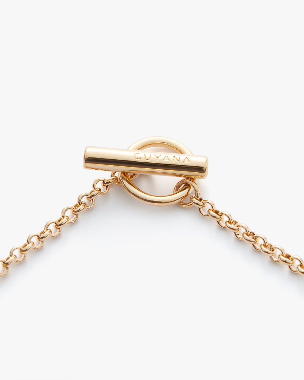 Golden toggle clasp on a chain with engraved brand name.