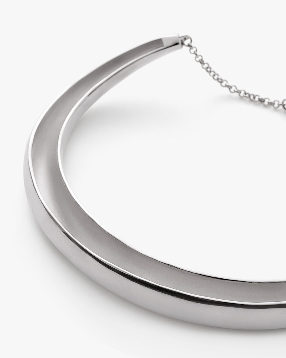 Metallic necklace with a curved design and attached chain.