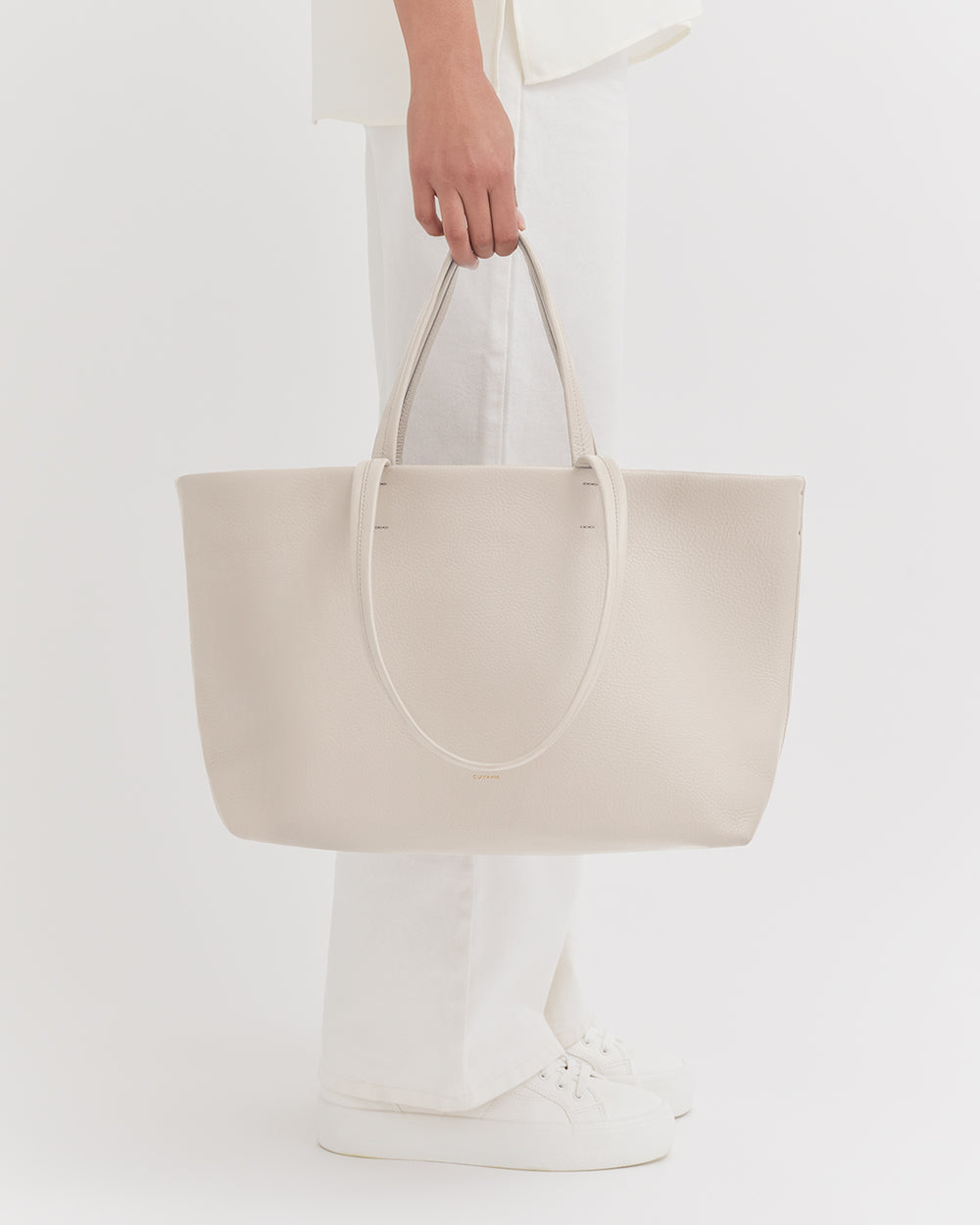 Small Easy Tote Person holding a large tote bag while standing.