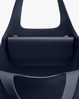 Close-up view of a handbag with a flap closure and handle.