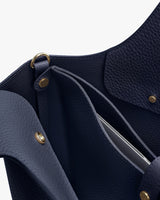 Close-up of an open handbag showing the interior and snap closures.