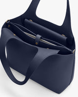 Open handbag with two handles and visible interior compartments.
