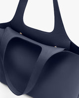 Close-up of a textured tote bag with handles.