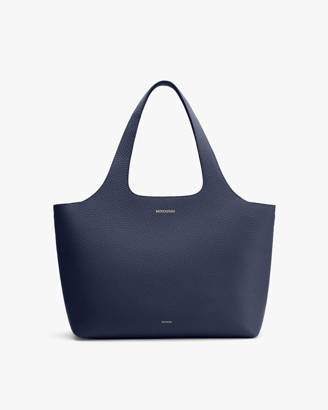 Large tote bag with two handles, brand logo at the bottom center.