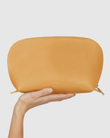 Hand holding a textured clutch purse.