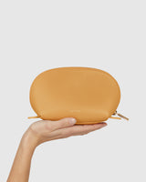 Hand holding a small zippered pouch.