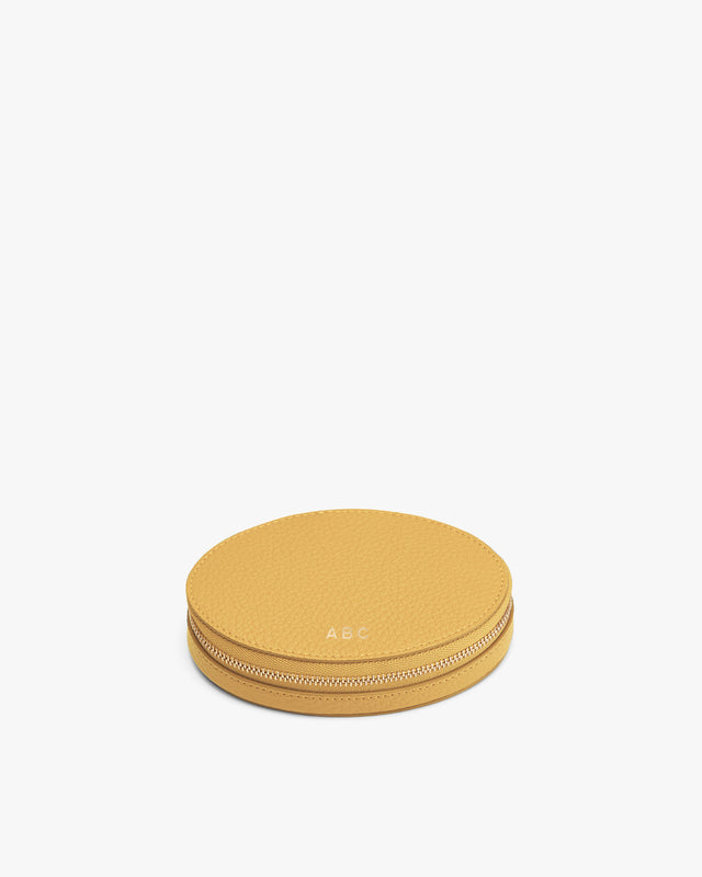 Round case with zipper featuring initials 'A.B.C' on top.