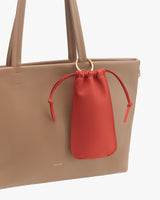 Tote bag with small red pouch attached by a ring.