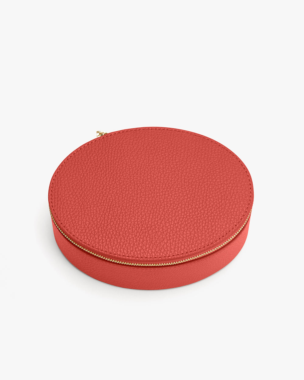 Round zippered leather box on a plain background.