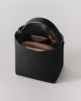 Open handbag with items inside, including a wallet and sunglasses.