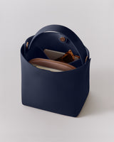 Open handbag with a phone, wallet, and sunglasses inside.