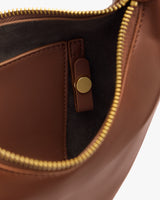 Open handbag with zipper and interior pocket with snap closure.