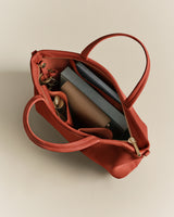 Open handbag containing tablet and zipped pouch