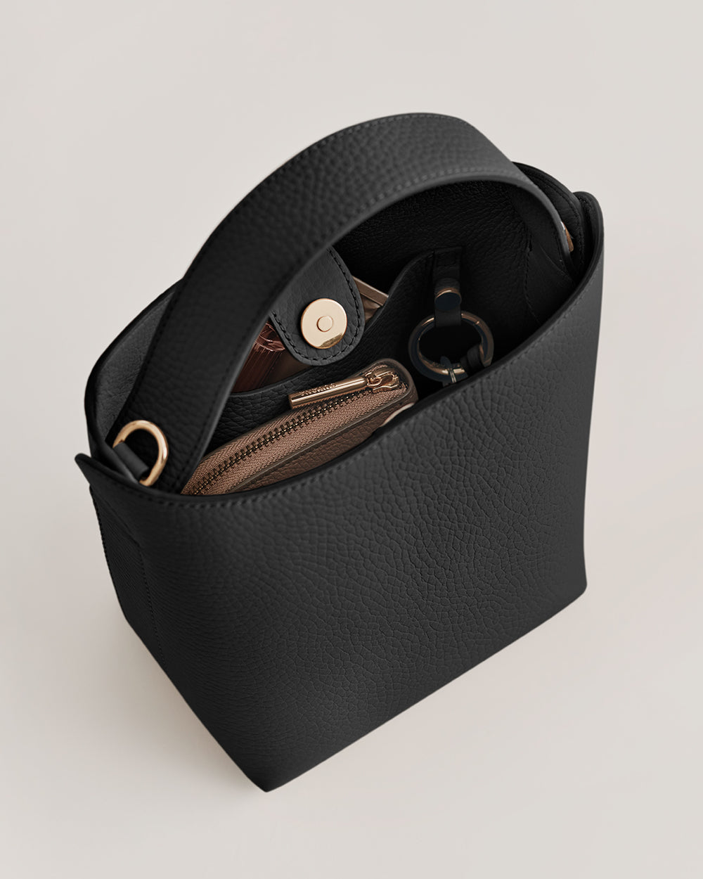 Open handbag with items inside, including a wallet and a small pouch.
