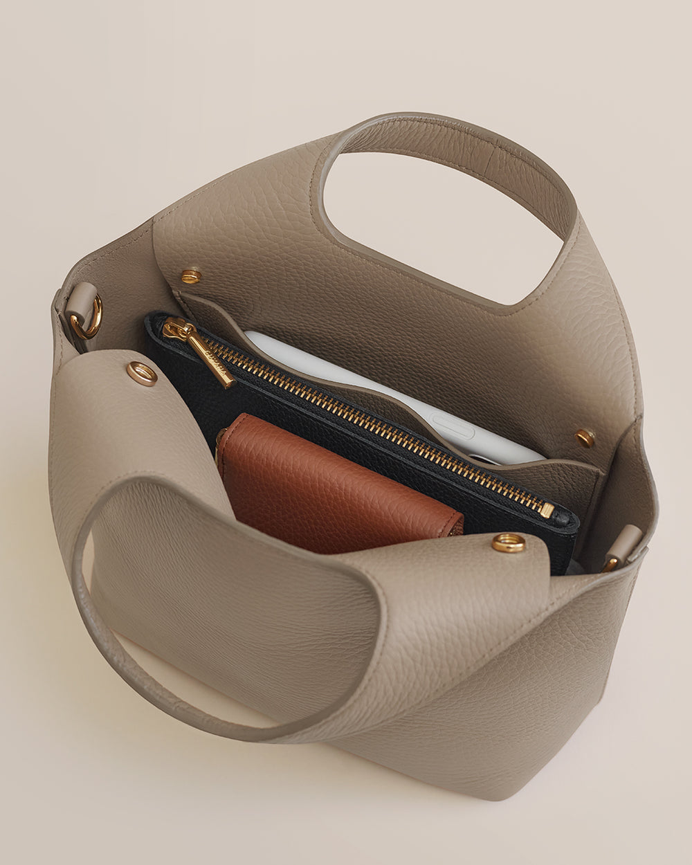 Mini System Tote Open handbag with items inside, including a wallet and a zippered pouch