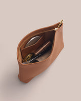 Open pouch holding glasses, compact, and a small item