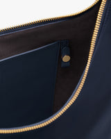 Close-up of an open bag with a pocket and metal zipper.