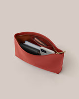 Open pouch with a phone, wallet, and other small items inside.