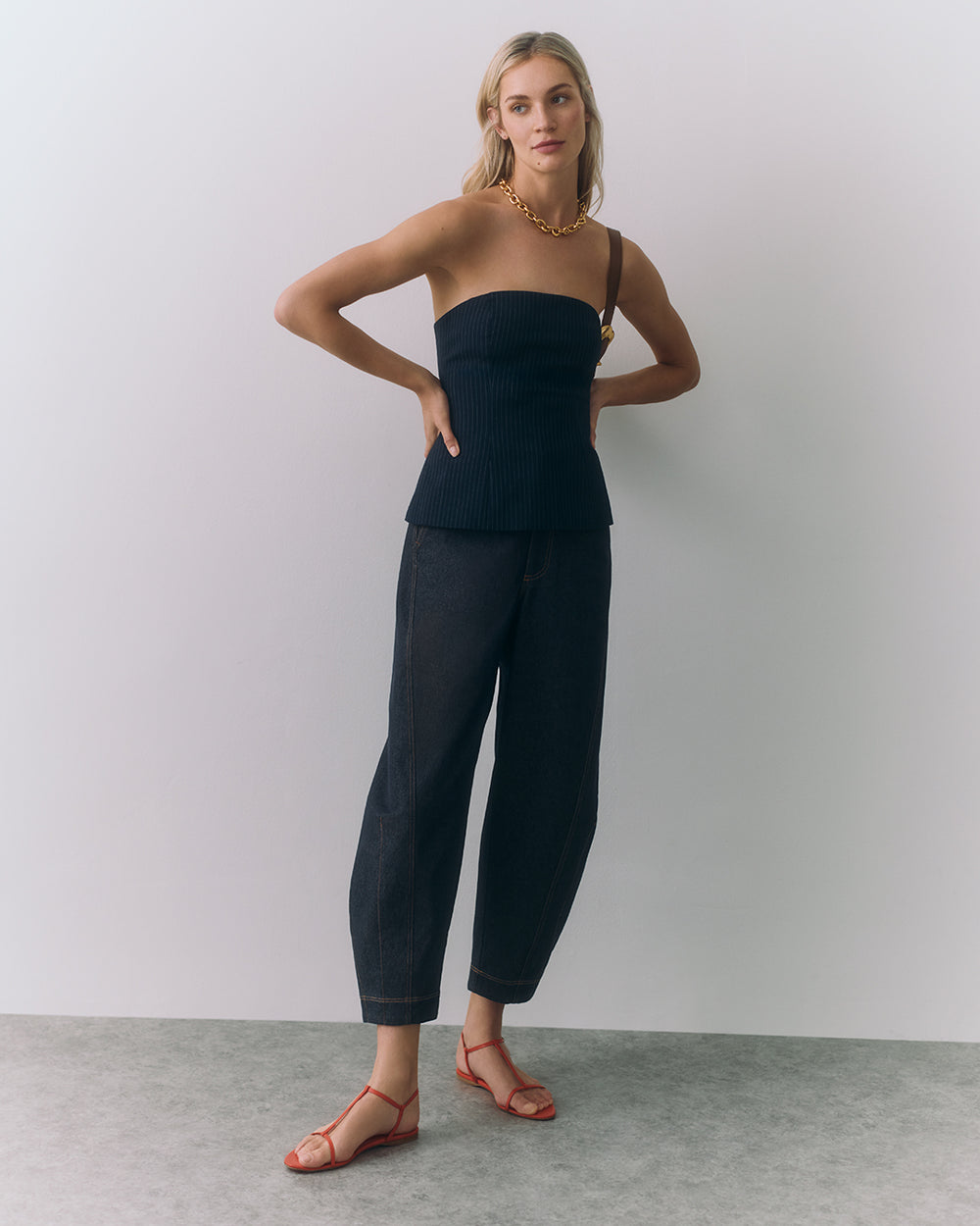 Barrel Pant Person wearing a strapless top, pants, and sandals, standing with arms on hips.