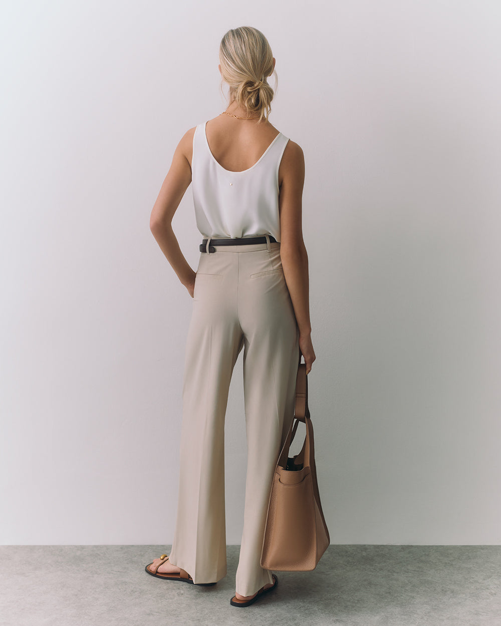 Silk Tank Person in tank top and pants holding a bag with one hand.