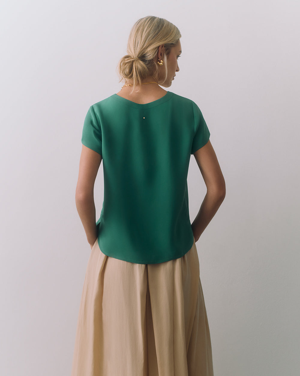 Person facing away, wearing a short-sleeve top and long skirt.