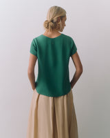 Person facing away, wearing a short-sleeve top and long skirt.