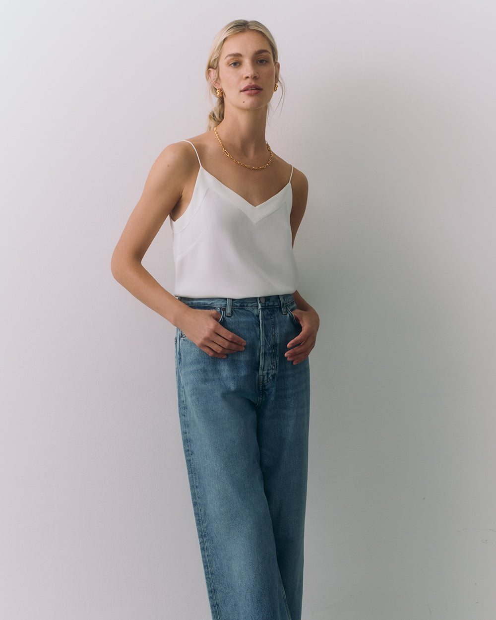 Silk Cami Person wearing a silk cami and jeans standing against a plain background.