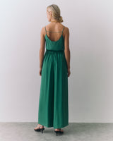 Person in a silk cami and wide leg pants, facing away from the camera.