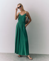 Woman in a a silk cami and wide-leg pants, wearing heels and sunglasses