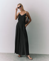 Woman in a a silk cami and wide-leg pants, wearing heels and sunglasses