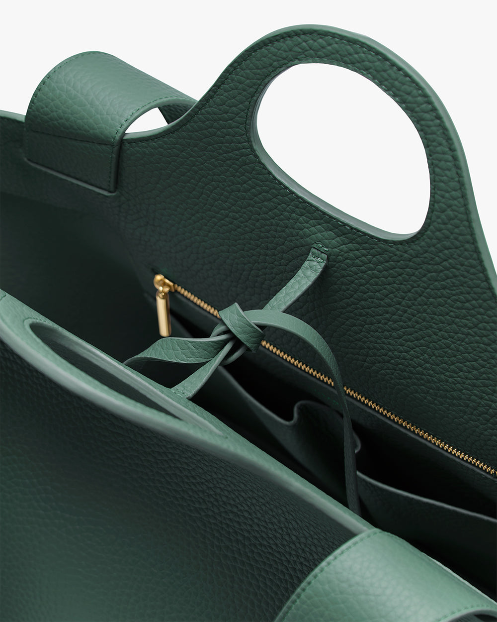 Paloma Tote Close-up of an open handbag with a zipper and tied strap inside.