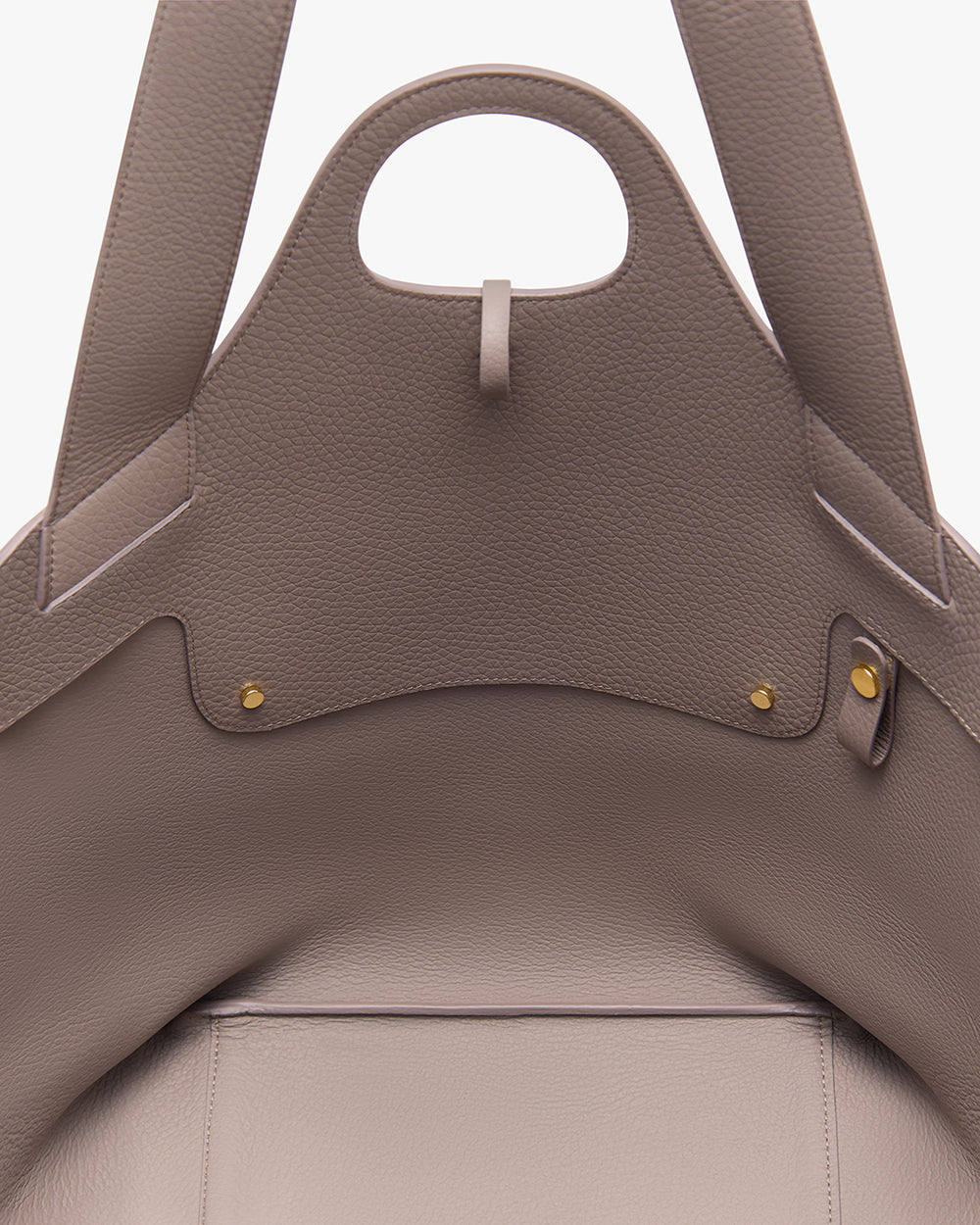 Paloma Tote Close-up of an open handbag with two handles and gold button details.