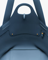 Close-up view of the interior top of a large open tote bag with two handles.