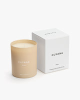 Candle beside its box with brand name and text visible.