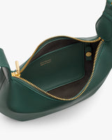 Open handbag with gold zipper showing a small interior pocket.