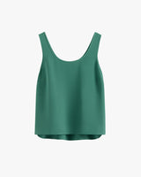 Sleeveless top with a rounded neckline hanging on plain background.
