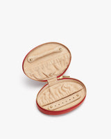 Small, round zippered jewelry case open, showing storage for rings and earrings.