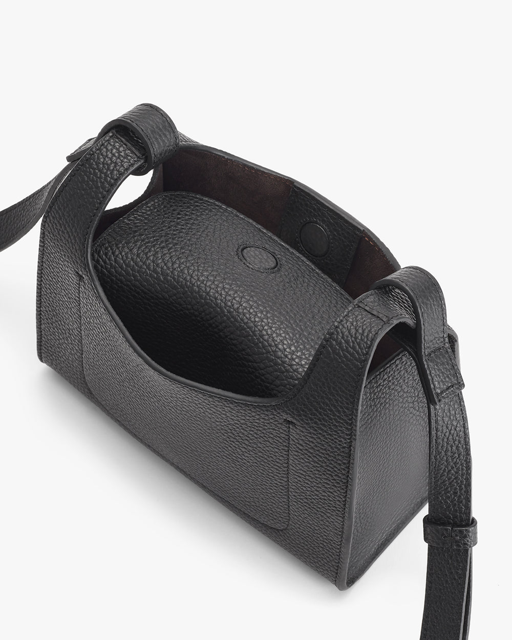 Open handbag with strap and button closure seen from above.