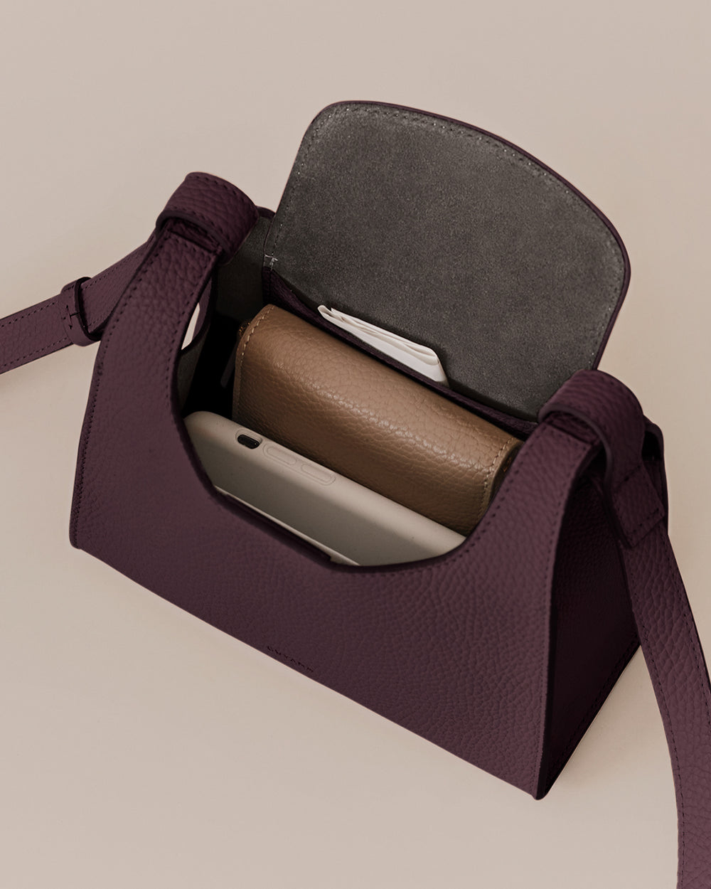 Mini Double Loop Bag Open handbag with a wallet and phone inside.