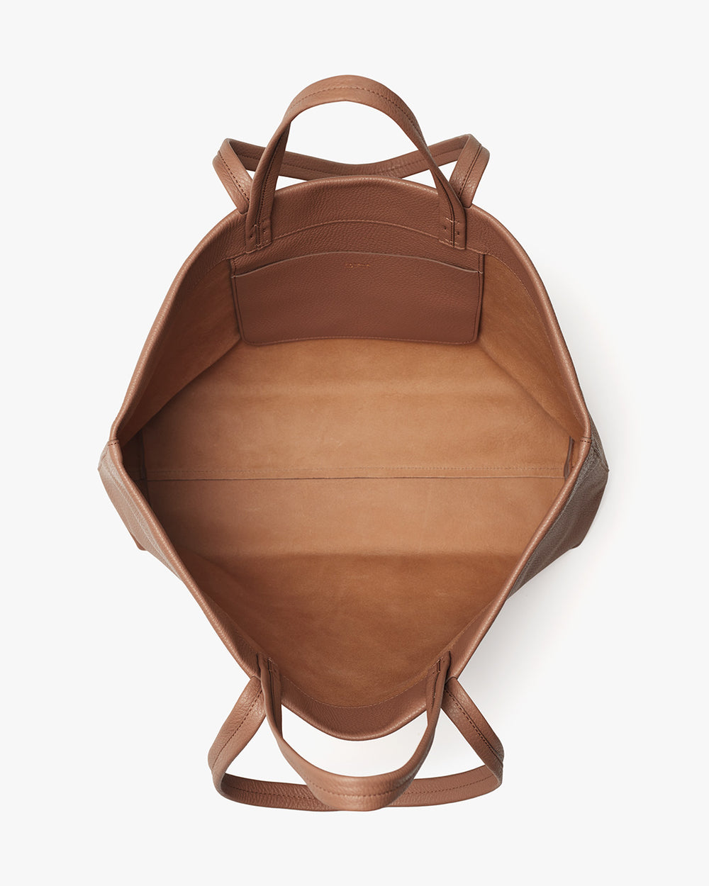 Top view of an open, empty leather bag with handles.