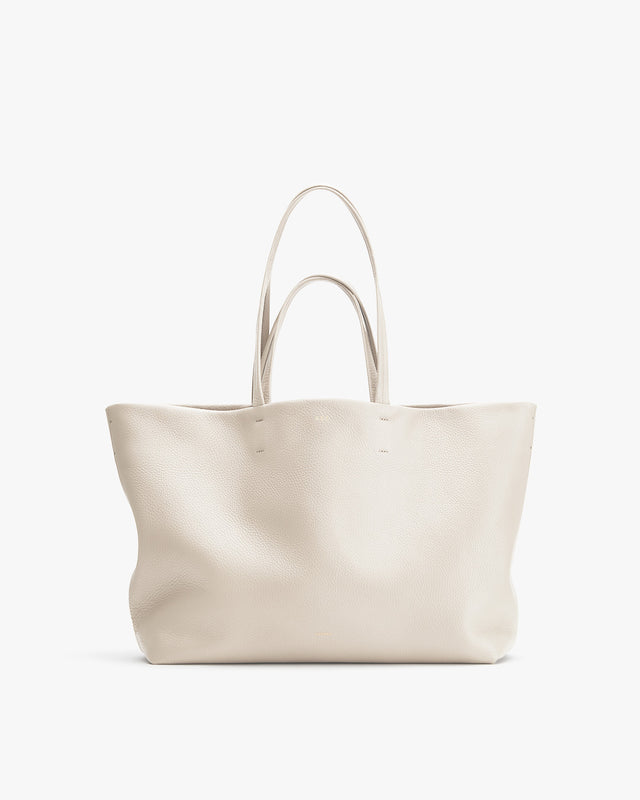 Large tote bag with dual handles standing upright.